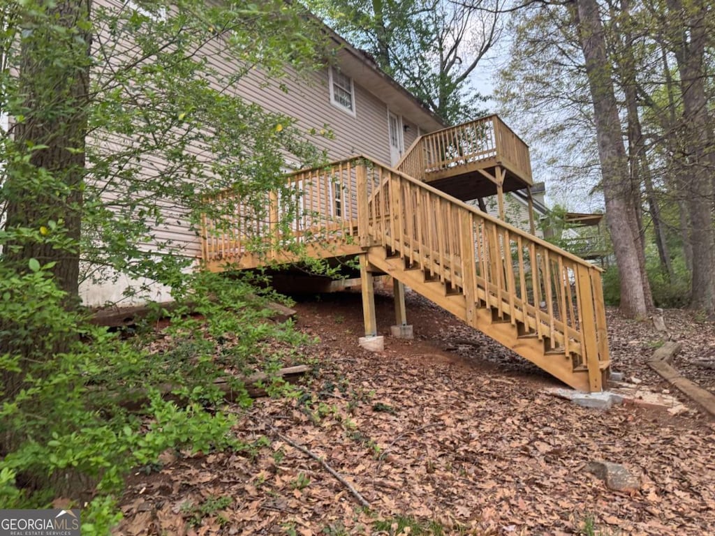 back of house featuring a wooden deck and stairs