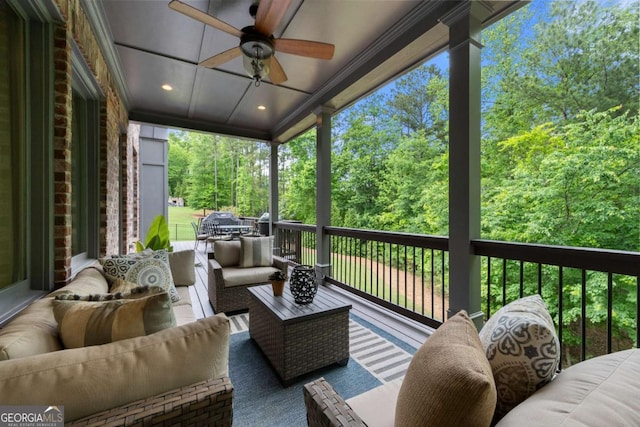 deck featuring an outdoor hangout area, ceiling fan, and view of wooded area