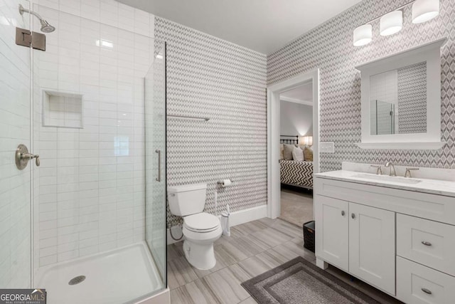 full bathroom with wallpapered walls, connected bathroom, toilet, a stall shower, and vanity