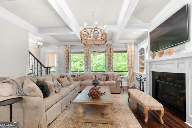 living area with a chandelier, wood finished floors, coffered ceiling, healthy amount of natural light, and stairs