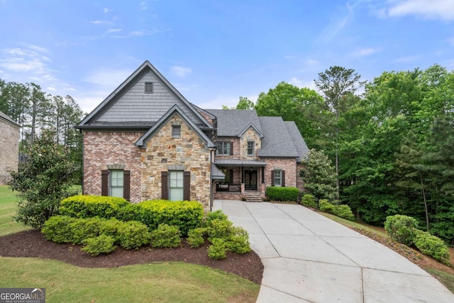 craftsman house featuring stone siding and driveway