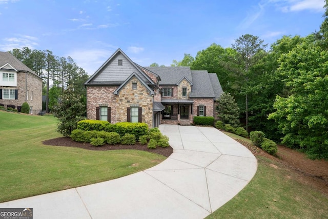craftsman-style house featuring stone siding, concrete driveway, a front yard, and a garage
