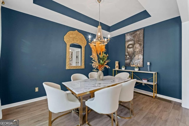 438 Southland Cir, Canton, GA 30115 - dining space featuring a chandelier, baseboards, a tray ceiling, and wood finished floors