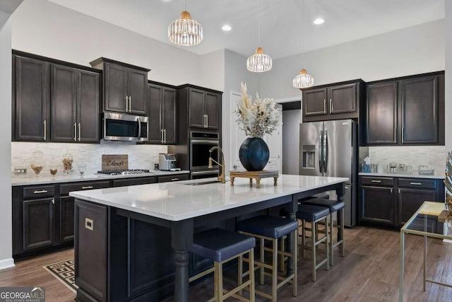 438 Southland Cir, Canton, GA 30115 - kitchen with appliances with stainless steel finishes, tasteful backsplash, a chandelier, light countertops, and a kitchen bar