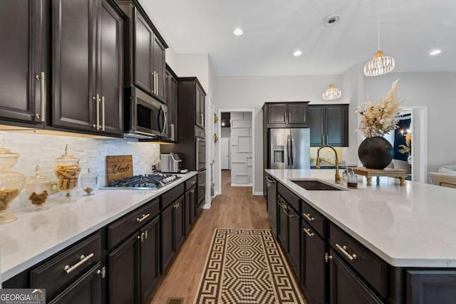 438 Southland Cir, Canton, GA 30115 - kitchen featuring a sink, appliances with stainless steel finishes, a center island with sink, backsplash, and pendant lighting