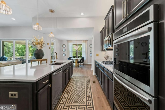 438 Southland Cir, Canton, GA 30115 - kitchen featuring a sink, stainless steel appliances, light wood-style floors, light countertops, and a kitchen island with sink