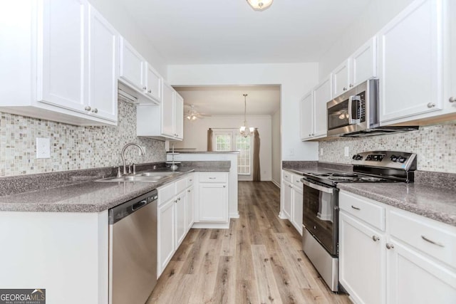 5138 Timber Hills Way, Oakwood, GA 30566 - kitchen with stainless steel appliances, a sink, white cabinetry, light wood finished floors, and decorative backsplash