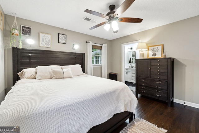 bedroom featuring dark wood-type flooring, baseboards, ceiling fan, and connected bathroom