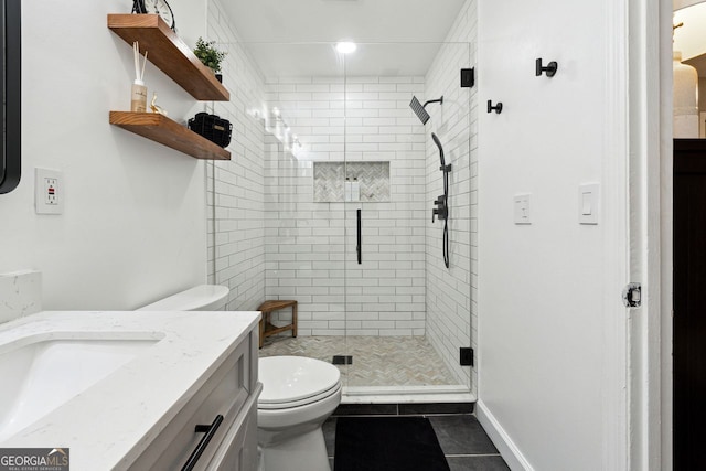 bathroom with toilet, a stall shower, vanity, and tile patterned flooring