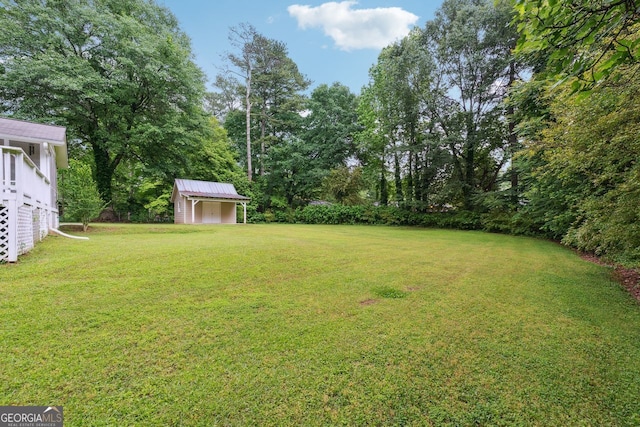 view of grassy yard featuring a storage shed and an outdoor structure