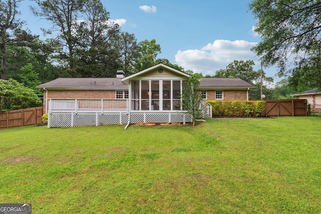 back of property featuring a sunroom and brick siding