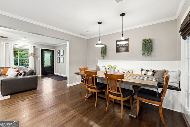dining area featuring wood finished floors, baseboards, and crown molding