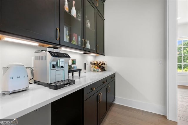 bar area featuring light wood-style flooring and baseboards
