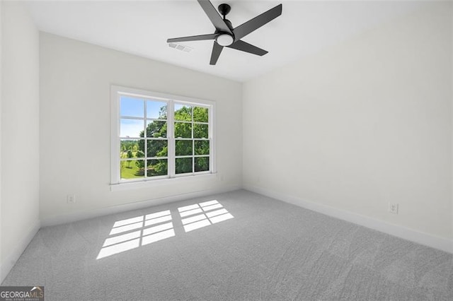 carpeted empty room with ceiling fan and baseboards
