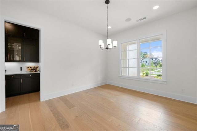 17145 River Overlook Dr, Roswell, GA 30075 - unfurnished dining area with a chandelier, light wood-style floors, recessed lighting, and bar area