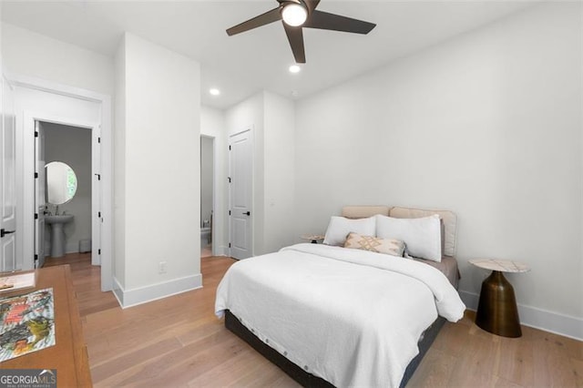 bedroom with baseboards, light wood-type flooring, recessed lighting, and ensuite bathroom