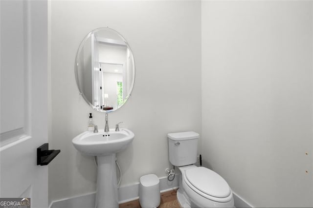 bathroom with toilet and baseboards