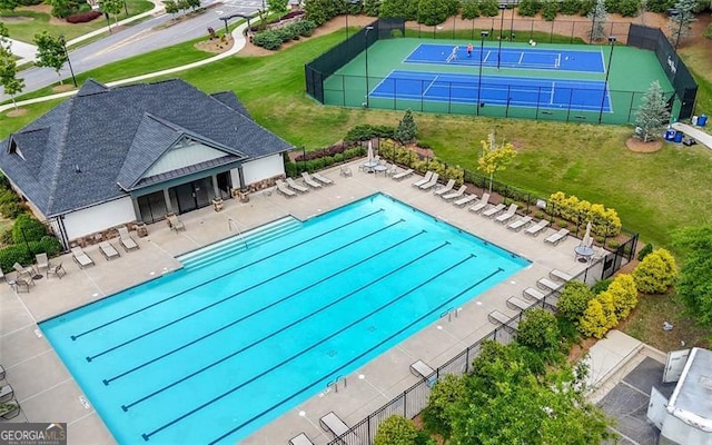 community pool featuring a tennis court and a patio