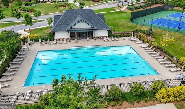 community pool with fence and a patio