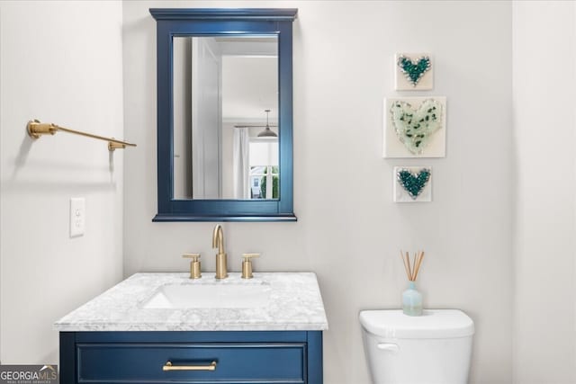 half bathroom featuring vanity and toilet