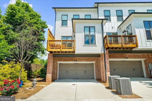 back of house featuring a balcony, an attached garage, and driveway