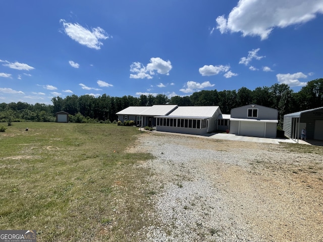 659 Voyles Rd, Carnesville, GA 30521 - view of front of house with an outdoor structure, gravel driveway, a storage unit, a detached garage, and a front lawn