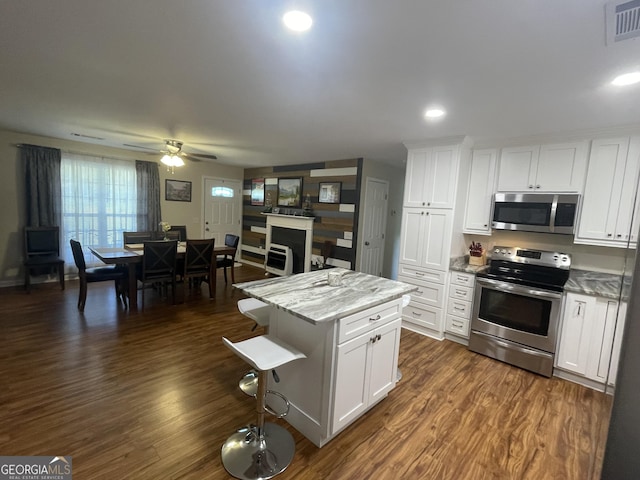 659 Voyles Rd, Carnesville, GA 30521 - kitchen with appliances with stainless steel finishes, white cabinets, a kitchen bar, ceiling fan, and recessed lighting