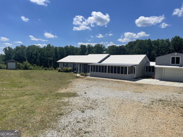 659 Voyles Rd, Carnesville, GA 30521 - single story home featuring a sunroom, an outbuilding, metal roof, driveway, and a garage