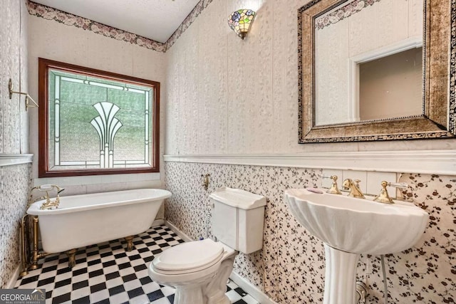 510 Aiken Dr, Dallas, GA 30157 - bathroom with tile patterned floors, toilet, a freestanding tub, wainscoting, and wallpapered walls
