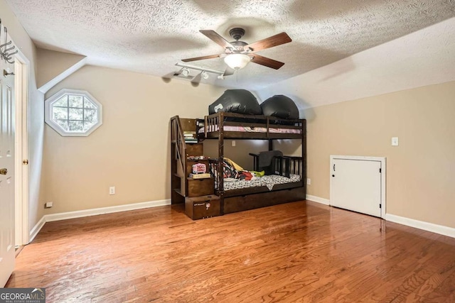510 Aiken Dr, Dallas, GA 30157 - bedroom with wood finished floors, a textured ceiling, lofted ceiling, baseboards, and a ceiling fan