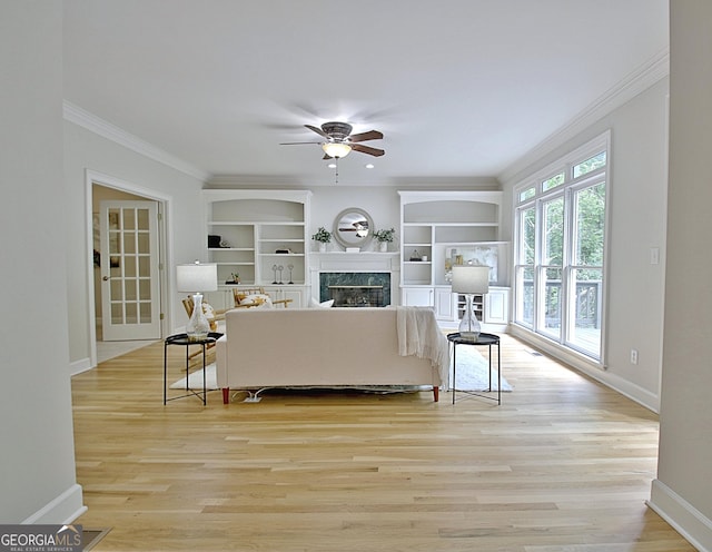 112 Windalier Rdg, Peachtree City, GA 30269 - living room with crown molding, a ceiling fan, baseboards, a premium fireplace, and light wood finished floors