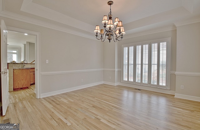 112 Windalier Rdg, Peachtree City, GA 30269 - empty room featuring a raised ceiling, a chandelier, light wood-style floors, and ornamental molding