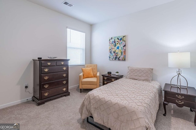 bedroom featuring light carpet and baseboards