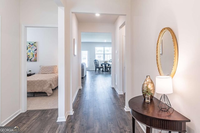 corridor featuring dark wood finished floors and baseboards