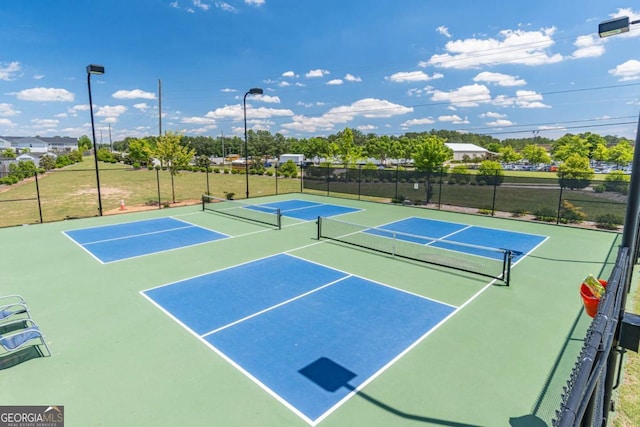 view of tennis court featuring fence and community basketball court