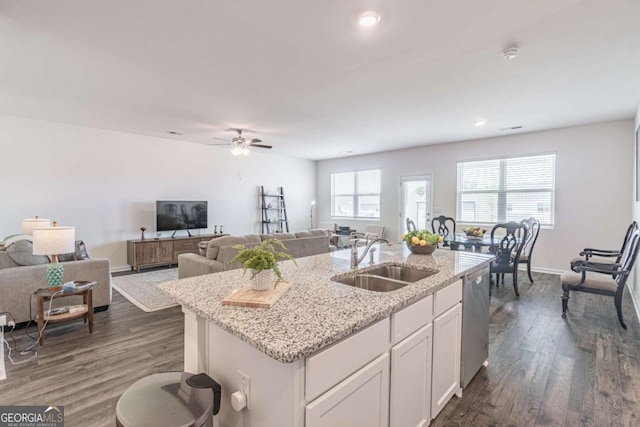 kitchen featuring a sink, dishwasher, a center island with sink, dark wood-type flooring, and white cabinetry