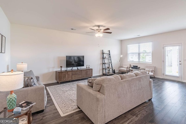 living area with dark wood-style floors, ceiling fan, and baseboards