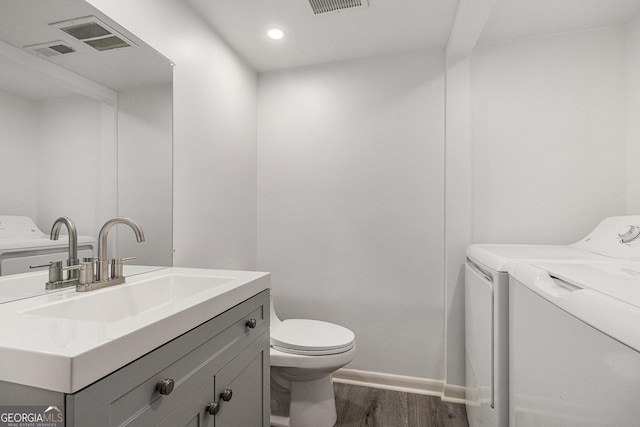 6900 Roswell Rd Unit F6, Atlanta, GA 30328 - bathroom with independent washer and dryer, vanity, wood finished floors, toilet, and recessed lighting