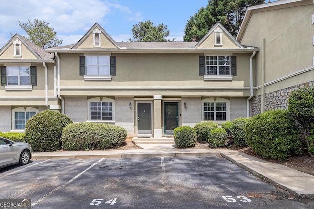 6900 Roswell Rd Unit F6, Atlanta, GA 30328 - view of property with uncovered parking, stucco siding, and brick siding