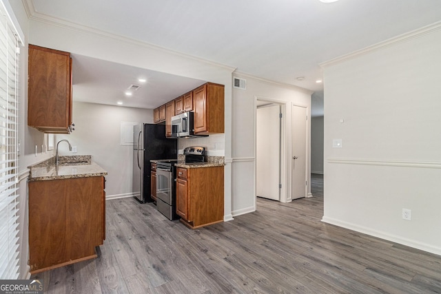 6900 Roswell Rd Unit F6, Atlanta, GA 30328 - kitchen with stainless steel appliances, brown cabinetry, dark wood-style flooring, a sink, and ornamental molding