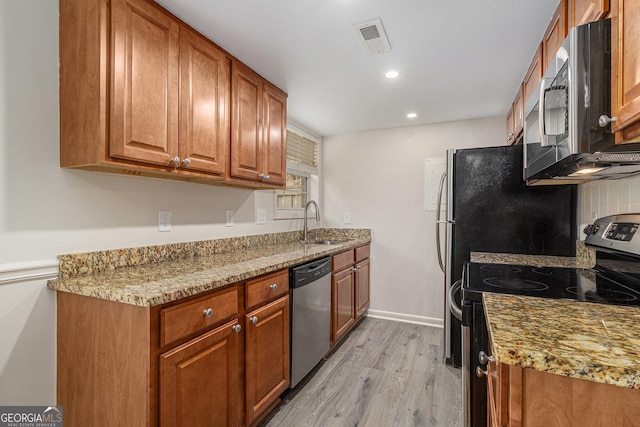6900 Roswell Rd Unit F6, Atlanta, GA 30328 - kitchen with stainless steel appliances, a sink, light wood finished floors, brown cabinets, and recessed lighting