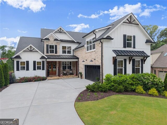 2149 Saddle Creek Dr, Jefferson, GA 30549 - view of front of property with board and batten siding, a standing seam roof, an attached garage, and driveway