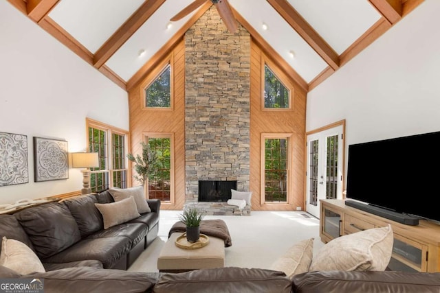 carpeted living area featuring high vaulted ceiling, beam ceiling, a fireplace, and a ceiling fan