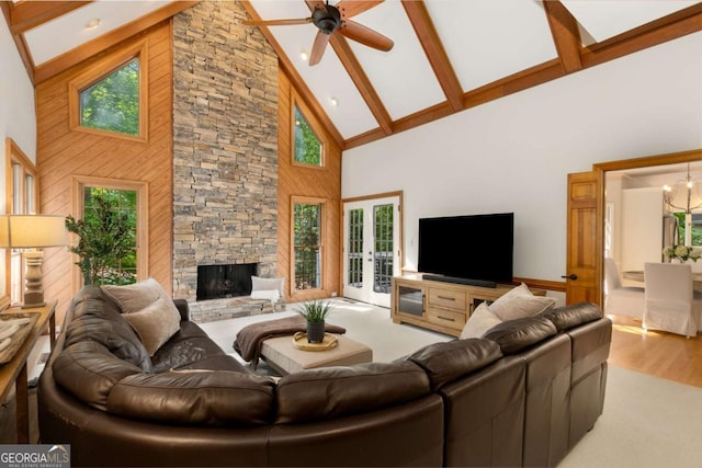 living room with high vaulted ceiling, plenty of natural light, beamed ceiling, a ceiling fan, and wood finished floors