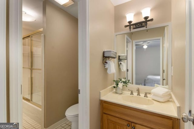 ensuite bathroom featuring tile patterned floors, toilet, vanity, ceiling fan, and bath / shower combo with glass door