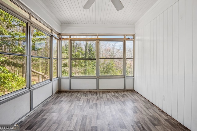 unfurnished sunroom featuring a ceiling fan and plenty of natural light