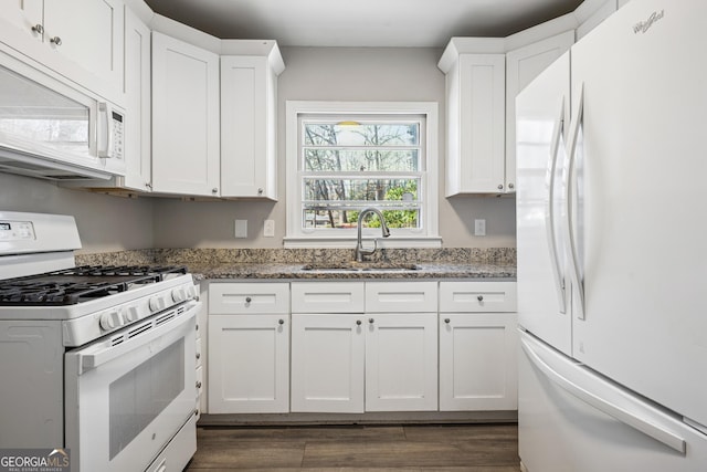 kitchen featuring white appliances, a sink, dark wood finished floors, and white cabinets