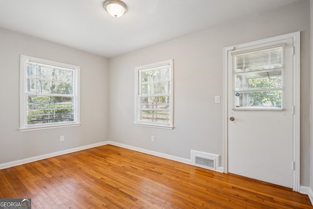 unfurnished room with light wood-style flooring and baseboards