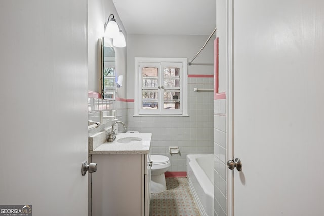 bathroom with tile walls, tile patterned flooring, toilet, vanity, and shower / bath combination