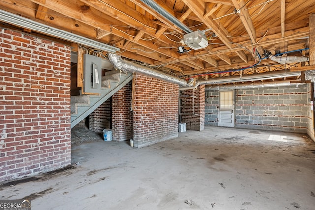unfinished below grade area featuring stairway and brick wall